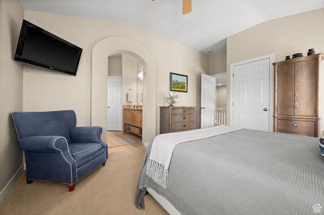 Bedroom featuring arched walkways, vaulted ceiling, and light carpet | Image 20