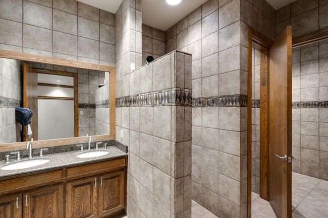 Full bathroom with a double vanity, and tile walls | Image 13