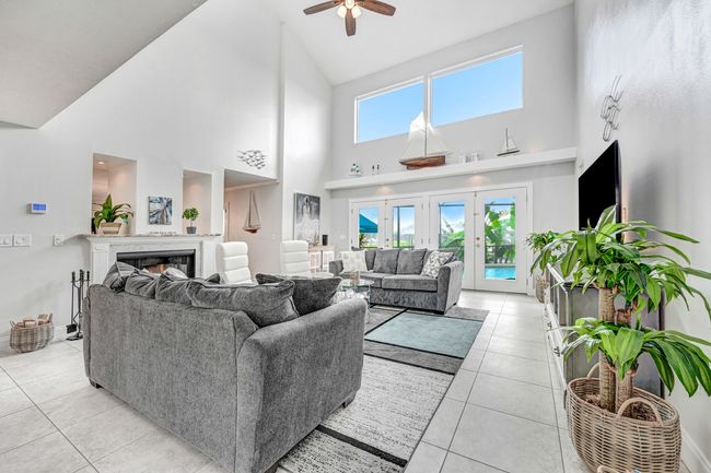Bright, open and airy living room with vaulted ceilings, skylights, fireplace and wall of sliders to the pool. | Image 6