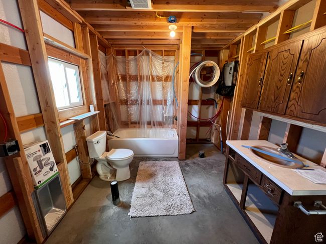Full bath with toilet, vanity, shower / bath combination with curtain, and concrete flooring | Image 28