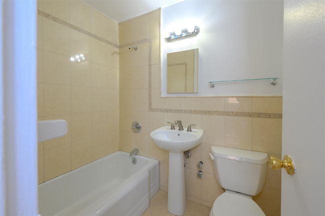 Bathroom featuring tile walls, tile patterned flooring, tiled shower / bath combo, and toilet | Image 9