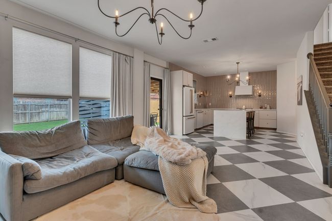 Living area with a chandelier, stairs, and light flooring | Image 10