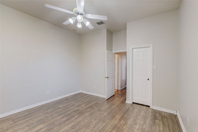 Empty room with light wood-type flooring, a ceiling fan, and baseboards | Image 31