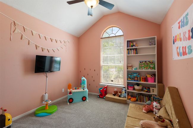 Bedroom featuring a ceiling fan, carpet flooring, and lofted ceiling | Image 11