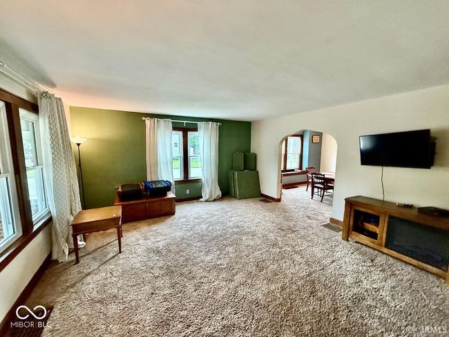 living area with arched walkways and carpet | Image 6