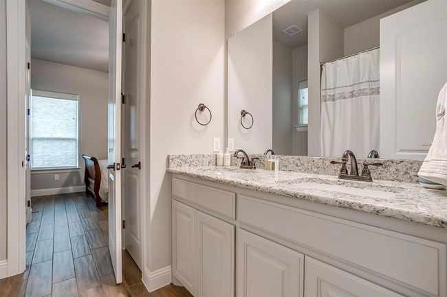 Full bathroom featuring double vanity and wood finished floors | Image 23