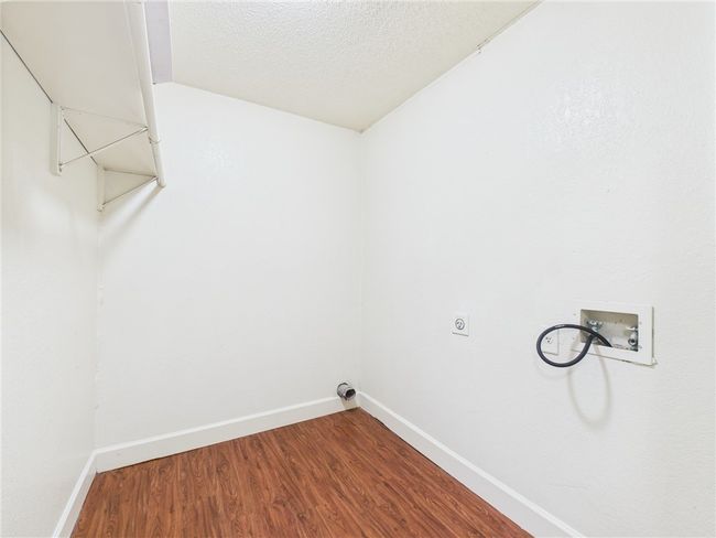 Laundry room featuring washer hookup, wood finished floors, hookup for an electric dryer, and a textured ceiling | Image 9