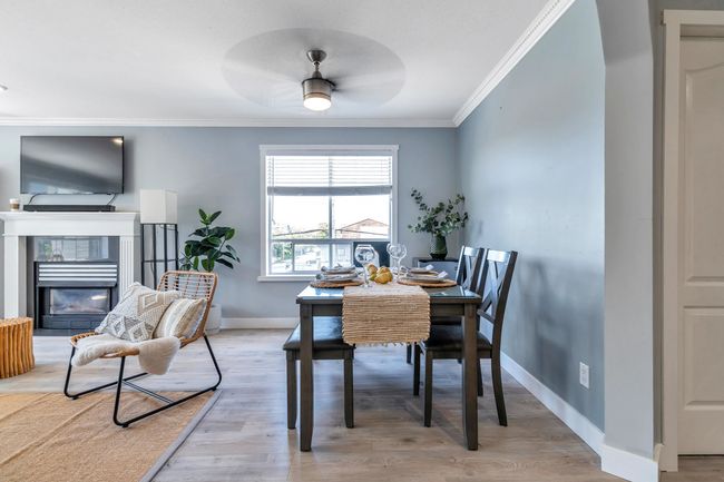 Dining area featuring crown molding, light wood-style flooring, a fireplace, and baseboards | Image 12