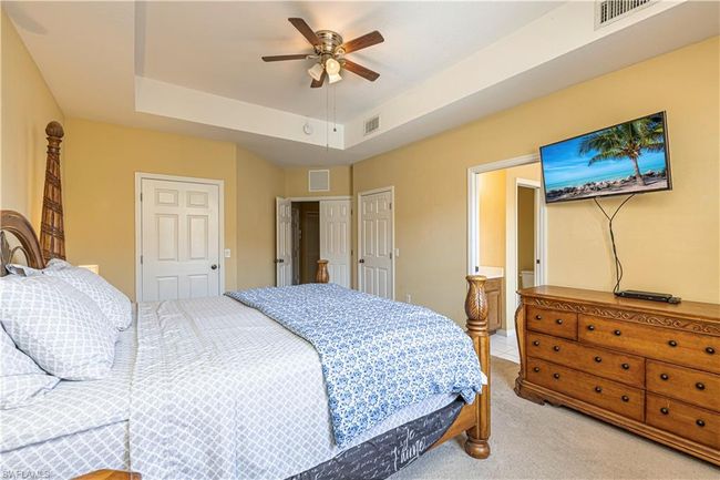 Bedroom with visible vents, light colored carpet, and a raised ceiling | Image 22