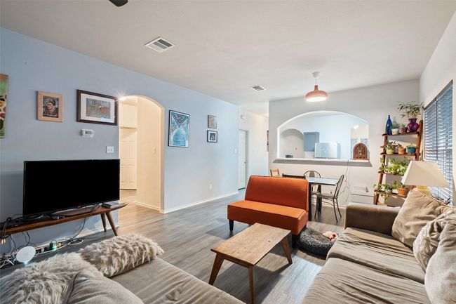 A large archway from the kitchen overlooks the dining and living with a corner fireplace with tile surround.Recent upgrades include vinyl plank flooring, water heater, range, roof and HVAC. | Image 20