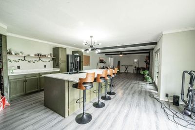 Kitchen with sink, light hardwood / wood-style flooring, refrigerator with ice dispenser, and a kitchen island with sink | Image 2