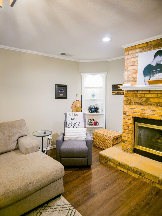 Living room with wood finished floors, ornamental molding, a brick fireplace, recessed lighting, and baseboards | Image 5