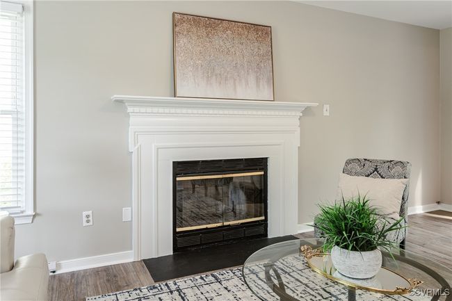 Room details featuring a fireplace with flush hearth, baseboards, and wood finished floors | Image 27