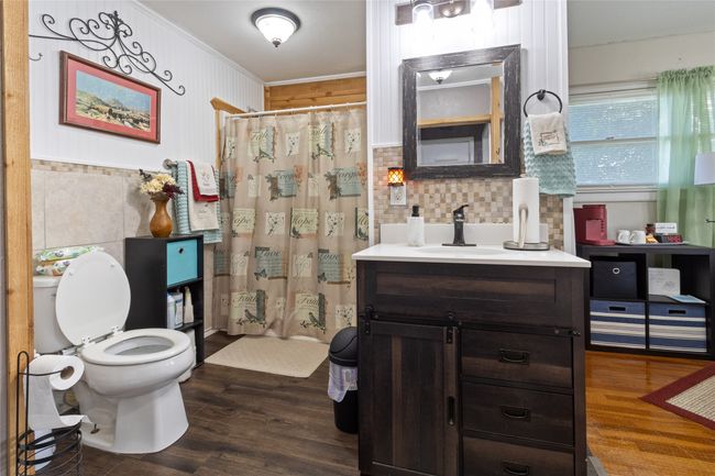 Bathroom featuring vanity, wood finished floors, ornamental molding, and decorative backsplash | Image 16