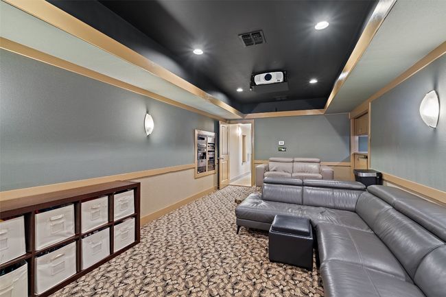 Carpeted home theater with a raised ceiling and recessed lighting | Image 22