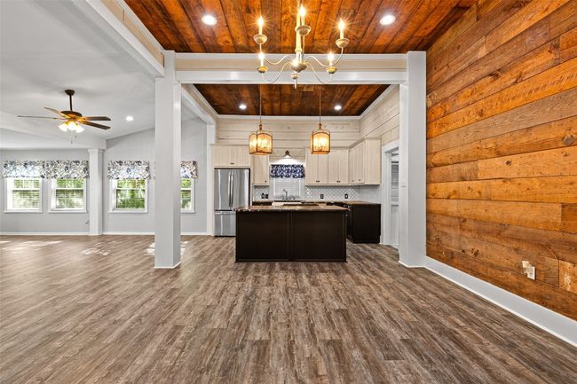 Kitchen featuring open floor plan, freestanding refrigerator, recessed lighting, wooden ceiling, and a kitchen island | Image 13