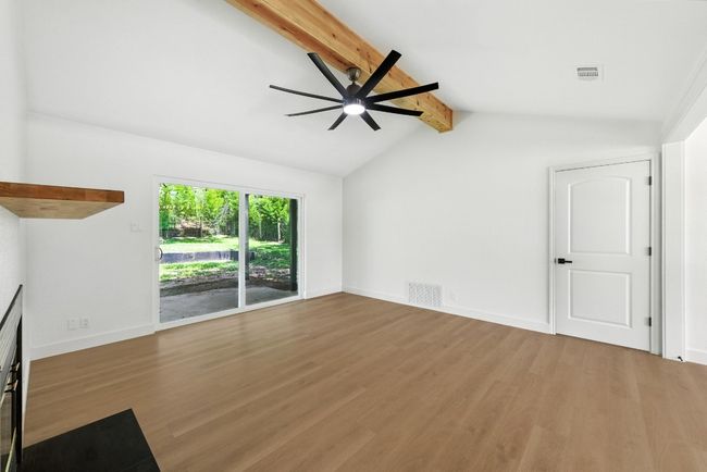 Unfurnished living room with wood finished floors and a ceiling fan | Image 7