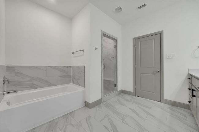 Bathroom with baseboards, a stall shower, a bath, visible vents, and marble finish floor | Image 24