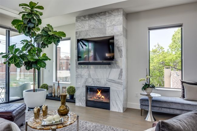 Living area with a premium fireplace, baseboards, and wood finished floors | Image 5