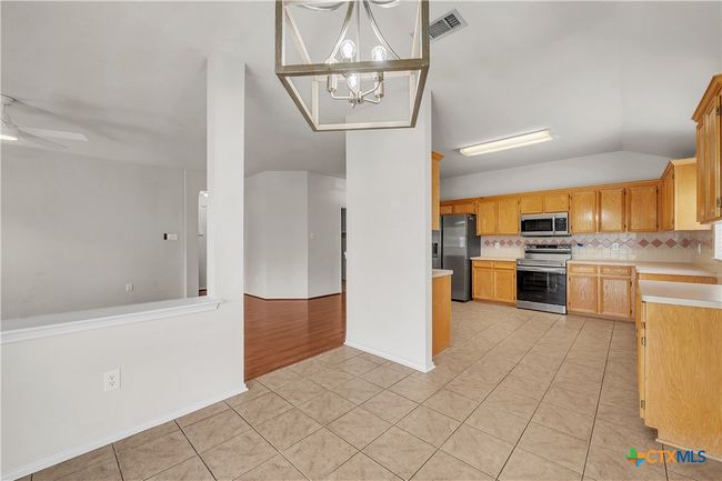 Neutral ceramic tile flooring, updated dining light fixture | Image 11