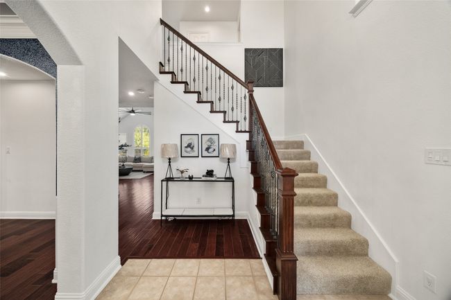 Stairway with arched walkways, baseboards, hardwood / wood-style floors, and ceiling fan | Image 6