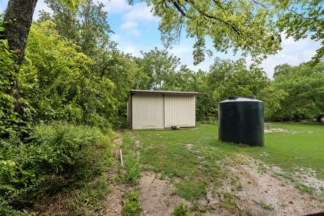 View of yard featuring a storage unit and an outdoor structure | Image 23