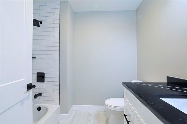 Full bathroom featuring toilet, tiled shower / bath, vanity, and tile patterned floors | Image 10