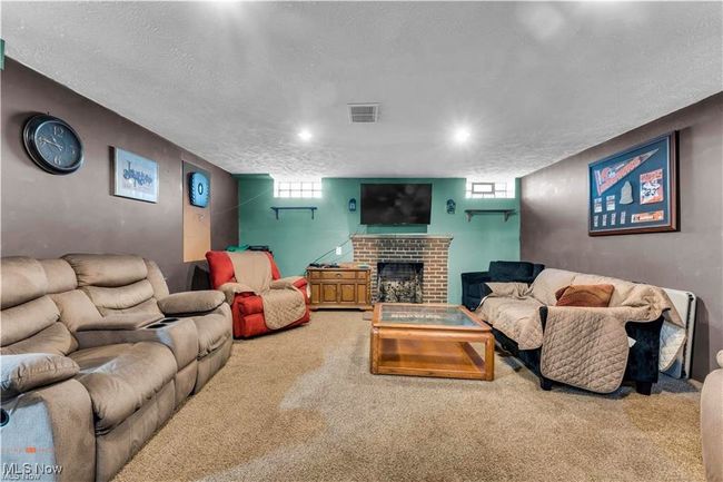 Living area with carpet, a fireplace, plenty of natural light, and a textured ceiling | Image 28