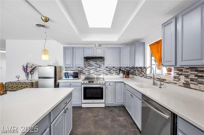 Kitchen with stainless steel appliances, gray cabinetry, a sink, and tasteful backsplash | Image 5