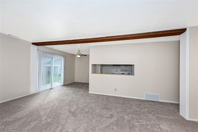 Unfurnished living room with ceiling fan and light colored carpet | Image 3