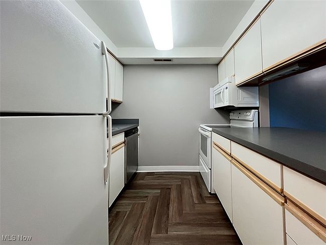 Kitchen with white appliances, white cabinets, and ample countertops | Image 7