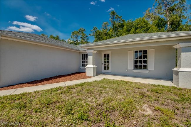 View of exterior entry with a yard and stucco siding | Image 4