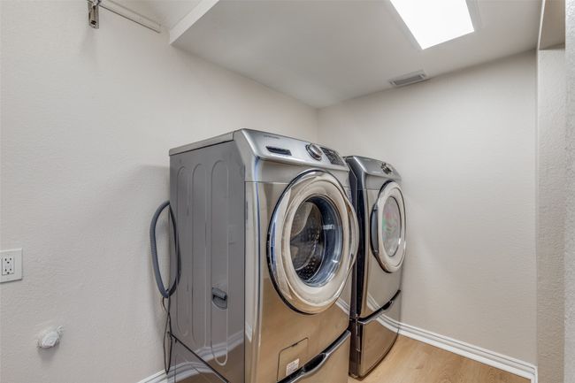Laundry area featuring separate washer and dryer, light wood-style flooring, and baseboards | Image 14