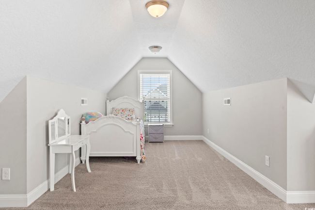 Carpeted bedroom with baseboards, vaulted ceiling, a textured ceiling, and visible vents | Image 31