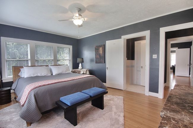 Bedroom with light wood-style flooring, baseboards, ornamental molding, a ceiling fan, and a textured wall | Image 12