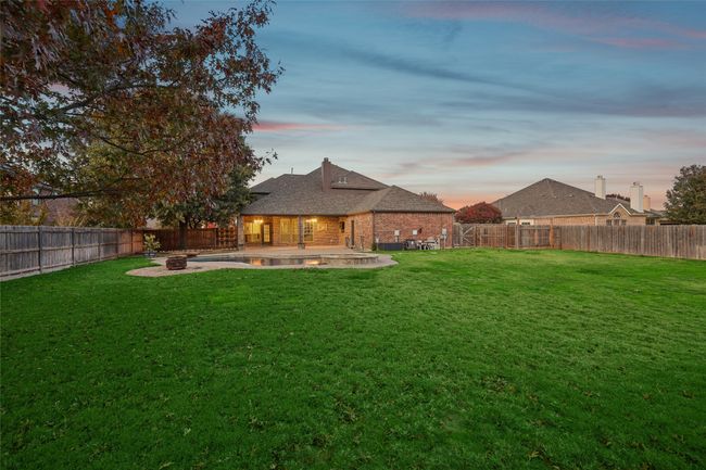 Yard at dusk featuring an outdoor fire pit and a patio area | Image 37
