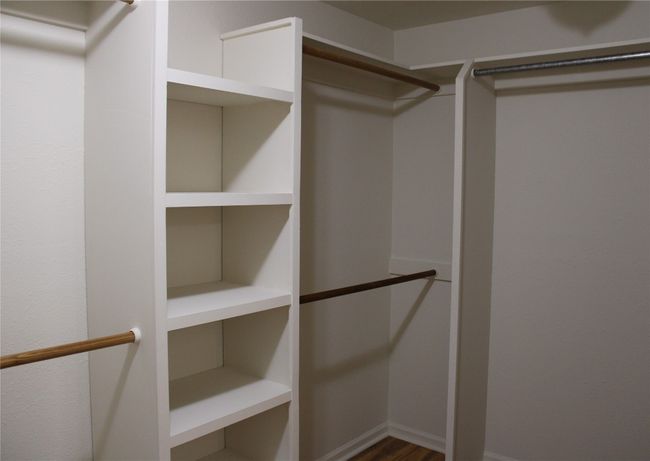 Spacious closet with dark wood-style floors | Image 15