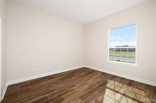 Spare room featuring dark wood-style flooring and baseboards | Image 15