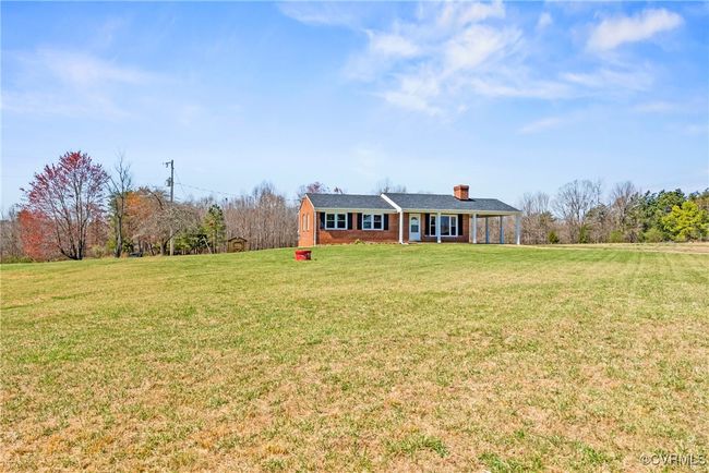 View of front of house featuring brick siding, a chimney, and a front lawn | Image 6