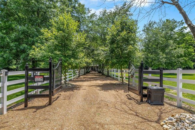 View of dirt / gravel driveway with a gate | Image 10