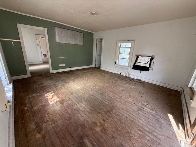 Unfurnished living room with hardwood / wood-style flooring and crown molding | Image 6