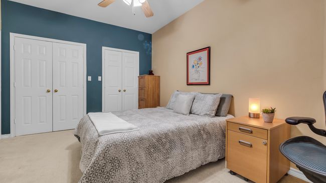 Bedroom featuring a ceiling fan, two closets, and light carpet | Image 15