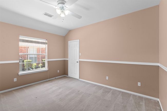 Carpeted empty room featuring a ceiling fan, lofted ceiling, and baseboards | Image 32