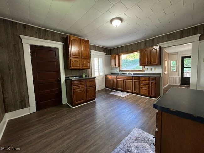 Kitchen featuring wooden walls, dark hardwood / wood-style flooring, and a wealth of natural light | Image 10