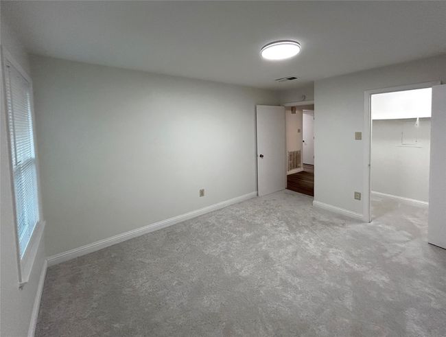 Unfurnished bedroom with a closet and light carpet | Image 30