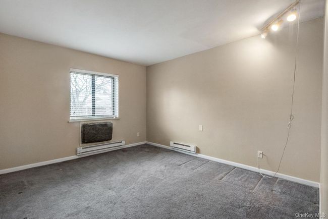 Carpeted spare room featuring baseboards and a baseboard heating unit | Image 19