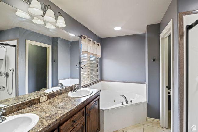 Bathroom with a whirlpool tub, a sink, and tile patterned floors | Image 13