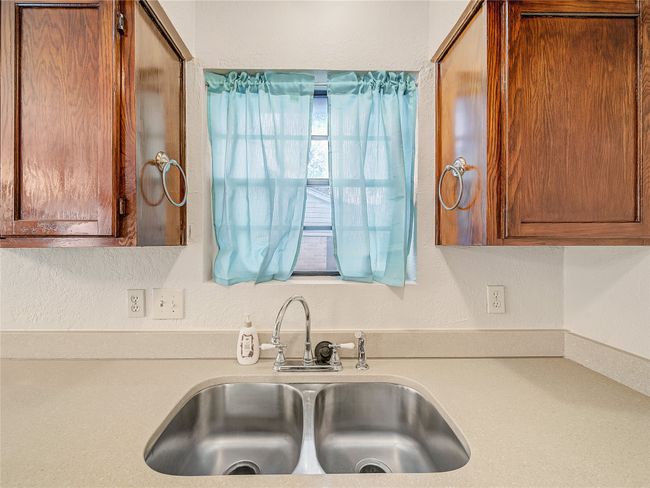 Kitchen featuring a sink, light countertops, and brown cabinetry | Image 10
