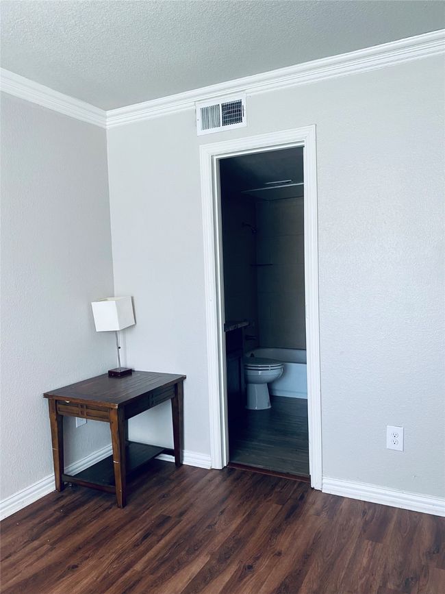 Hall featuring ornamental molding, dark wood-type flooring, and a textured ceiling | Image 4