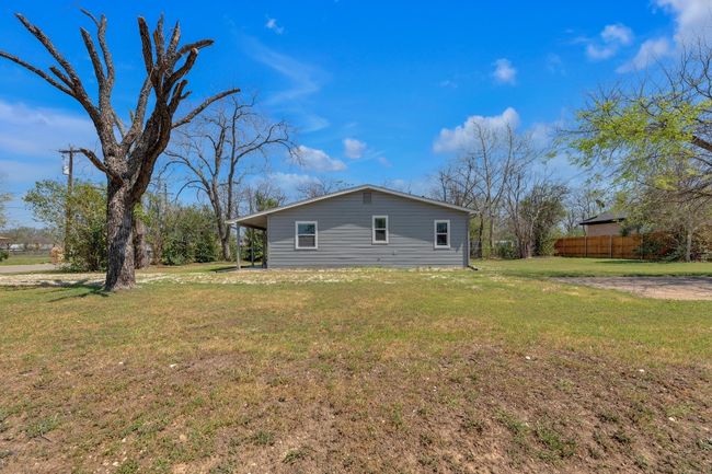 View of side of home with a lawn and fence | Image 23